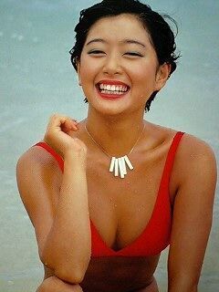 夏目雅子が右手を右膝にあてビキニ姿で笑顔